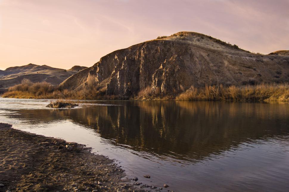Free Image of A body of water with a hill in the background 