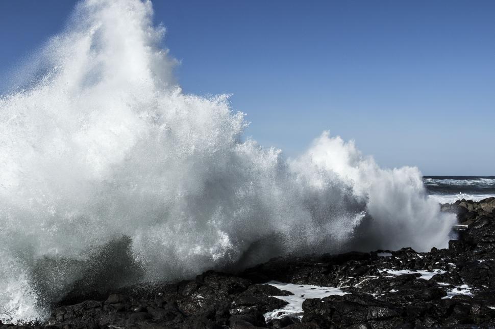 Free Image of A wave crashing on rocks 