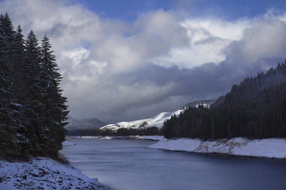 Free Image of A lake with snow and trees 