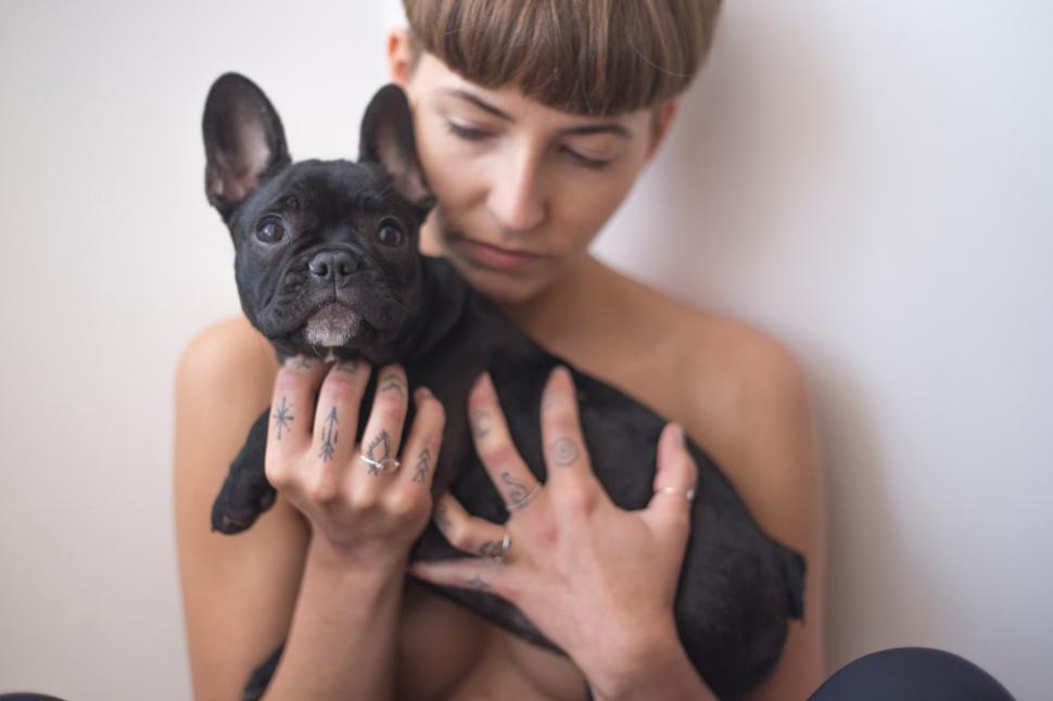 Free Image of A woman holding a small dog 