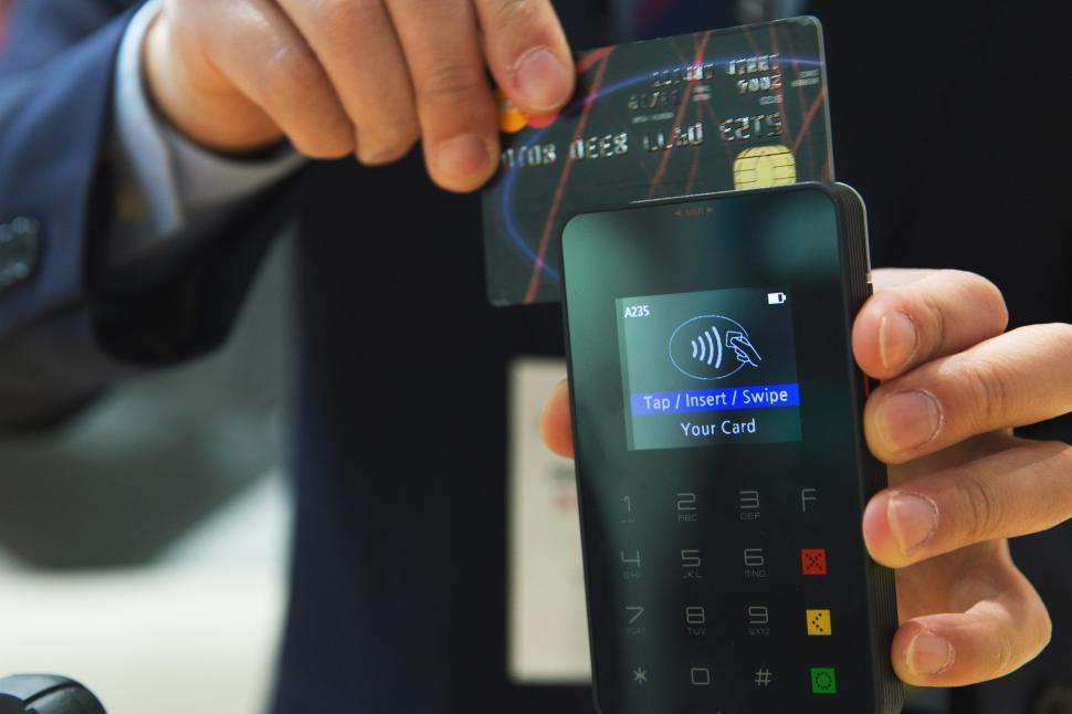 Free Image of A person holding a credit card and a phone 
