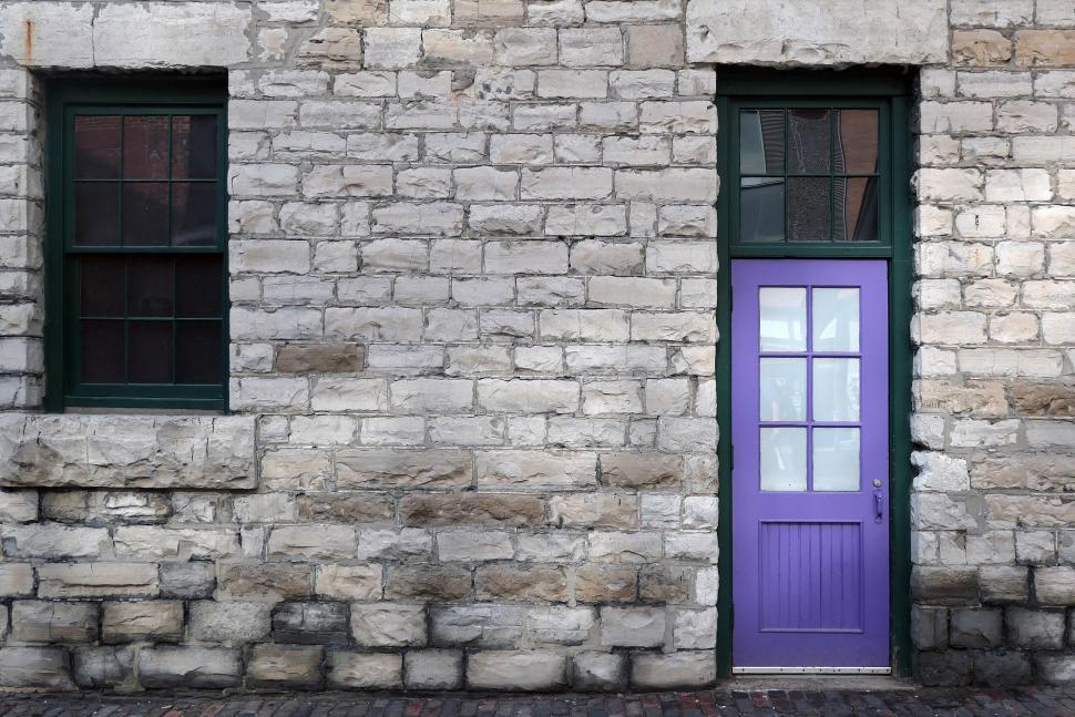 Free Image of A purple door next to a stone building 