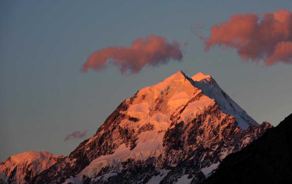 Free Image of A snowy mountain with a pink cloud in the sky 