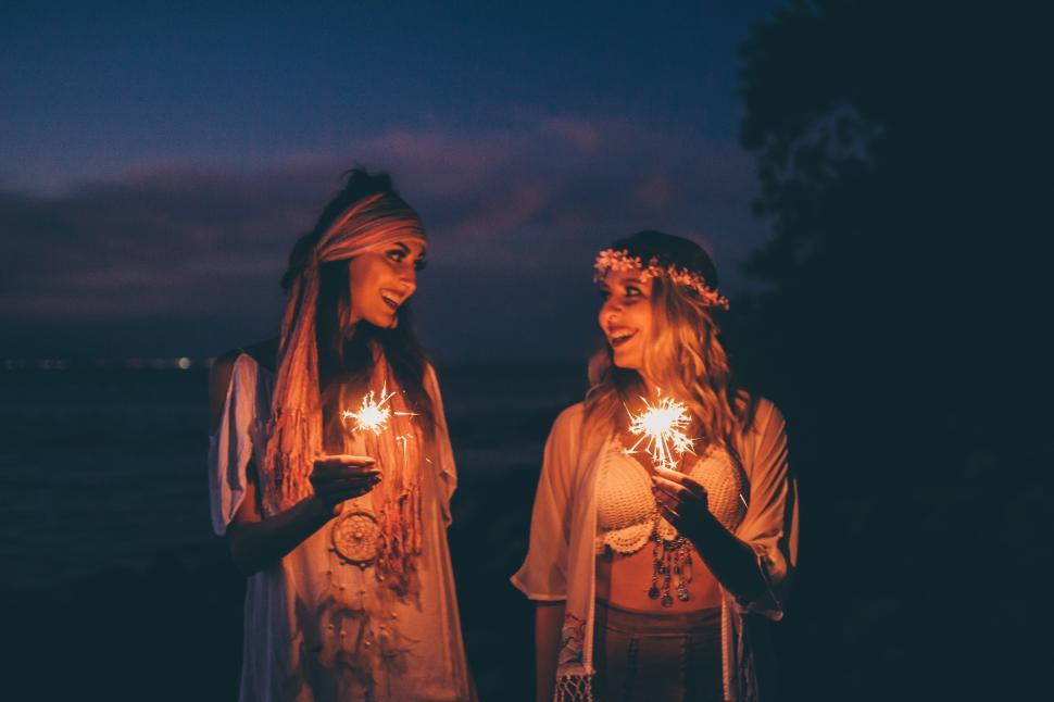 Free Image of Two women holding sparklers at night 