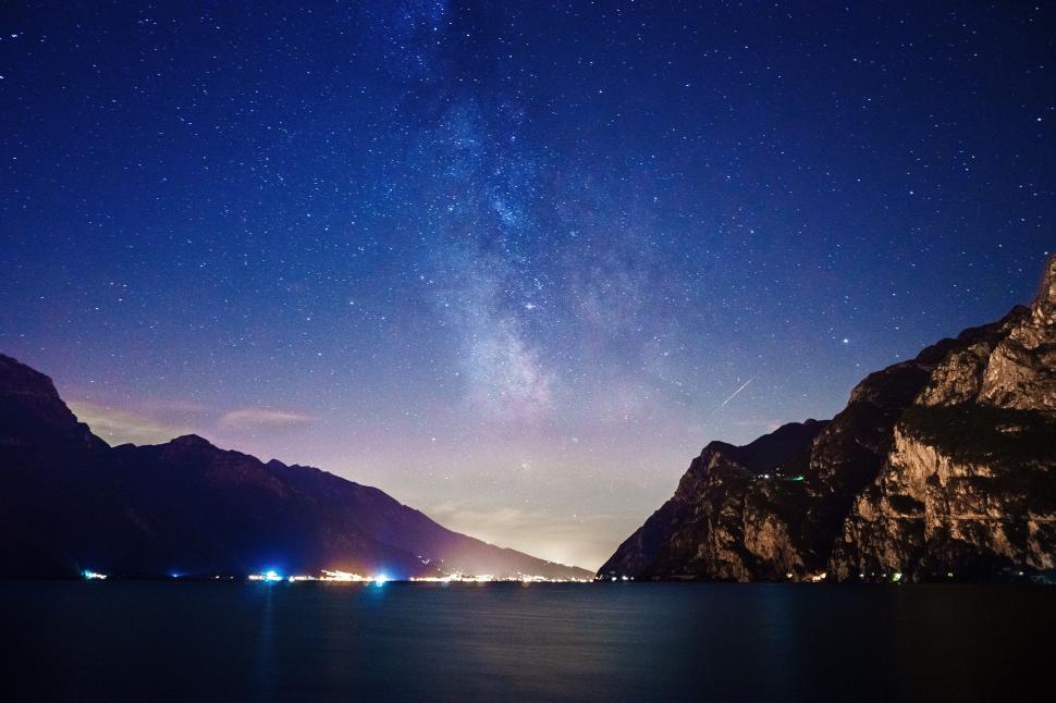 Free Image of A body of water with mountains and lights in the sky 