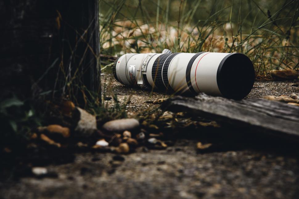 Free Image of A camera lens lying on the ground 