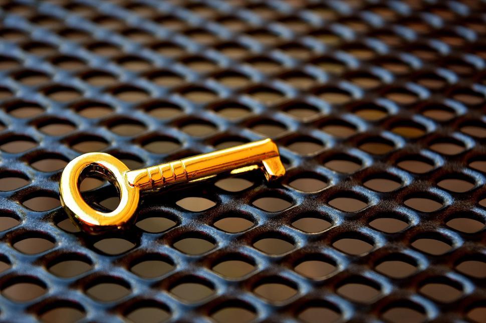 Free Image of A gold key on a black surface 