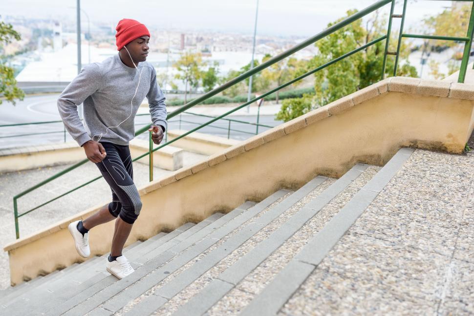 Free Image of Black man running upstairs outdoors in urban background 