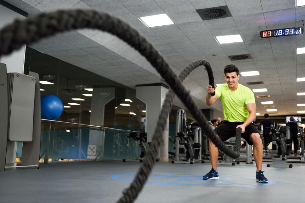Free Image of Man with battle ropes exercise in the fitness gym. 