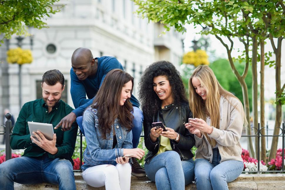 Free Image of Multi-ethnic young people using smartphone and tablet computers outdoors 
