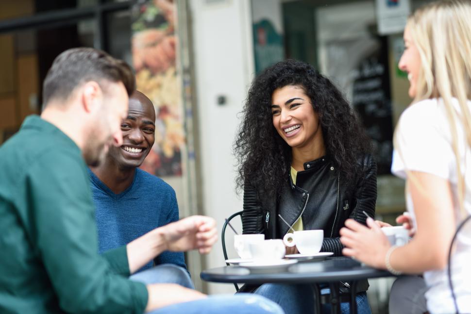 Free Image of Multiracial group of four friends having a coffee together 