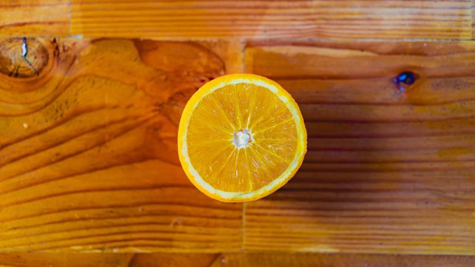 Free Image of A sliced orange on a wood surface 