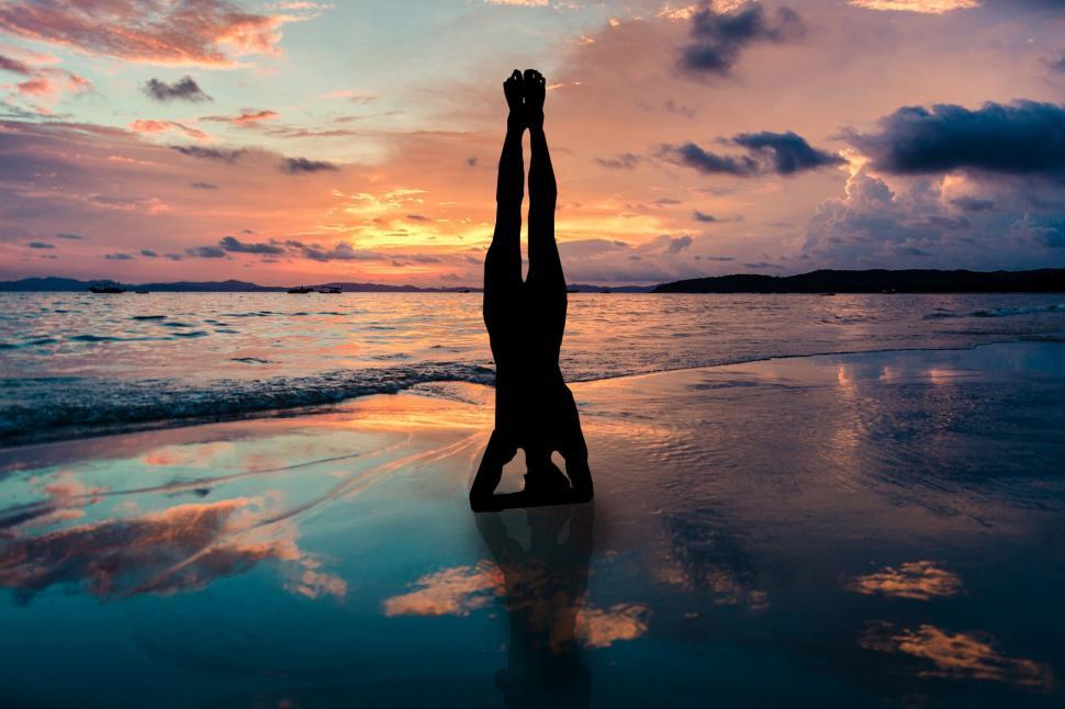 Free Image of A person doing a handstand on a beach 
