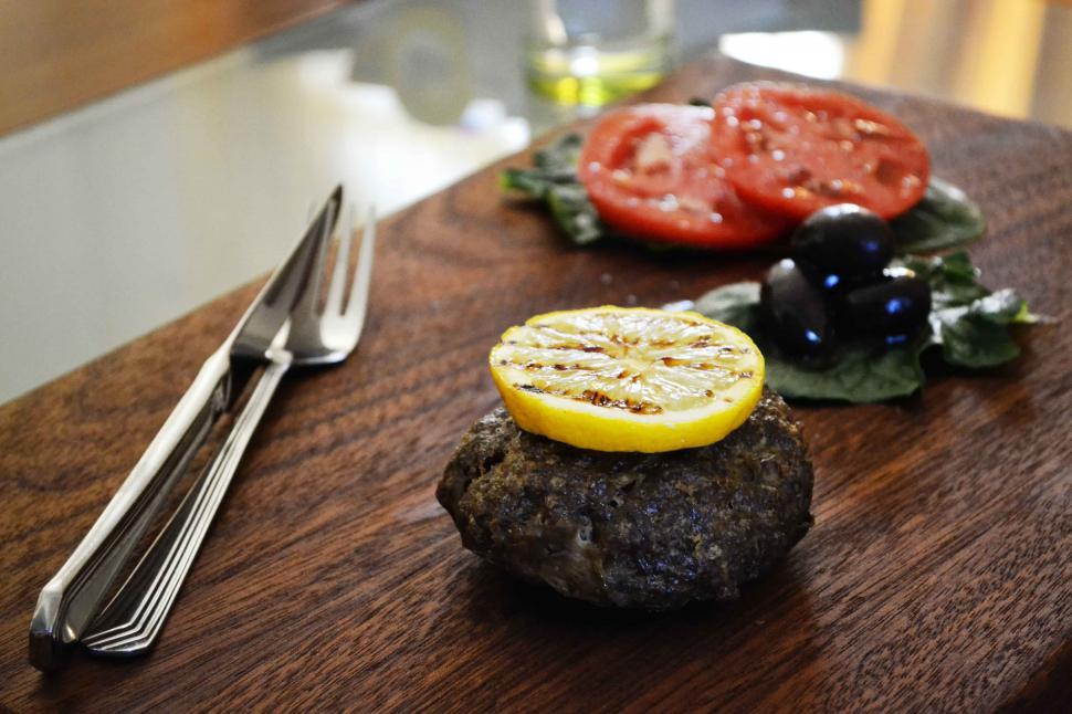 Free Image of A piece of meat with lemon on top of it 