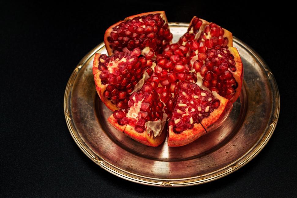 Free Image of A pomegranate cut in half on a plate 