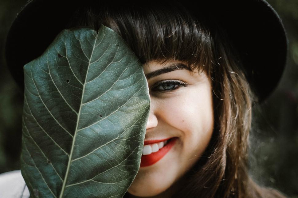 Free Image of A woman covering her face with a leaf 