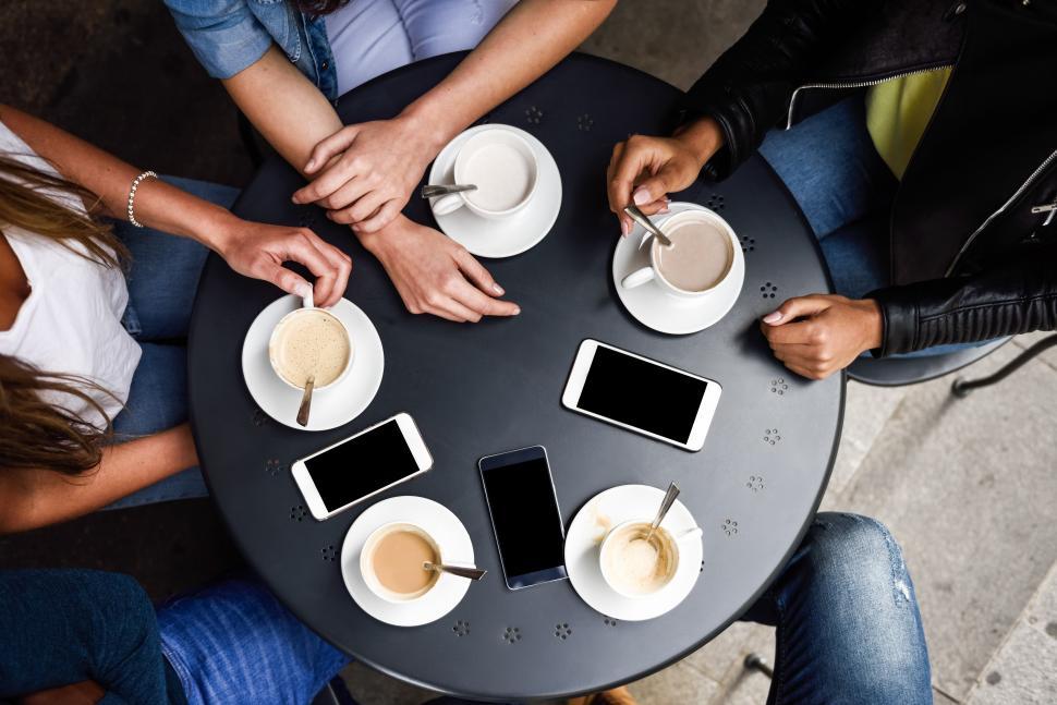 Free Image of Hands with coffee cups and smartphones in a urban cafe. 