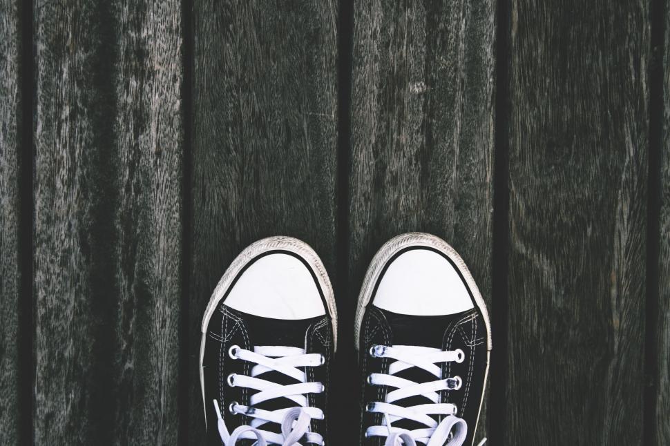 Free Image of A pair of black and white sneakers on a wooden surface 