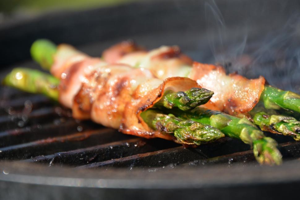 Free Image of A green asparagus wrapped in bacon on a grill 