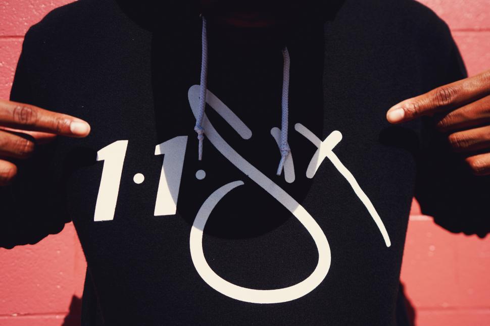 Free Image of A person wearing a black hoodie with white text on it 