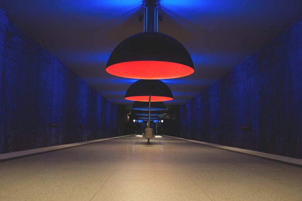 Free Image of A long hallway with a red and black light fixture at Munch Metro Station 