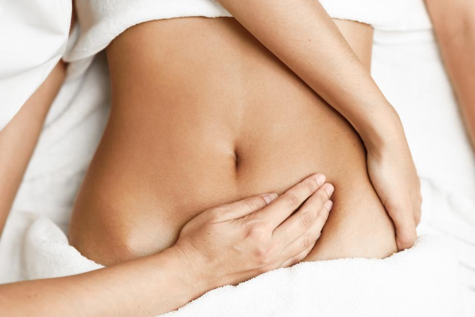 Free Image of Hands massaging female abdomen.Therapist applying pressure on belly. 