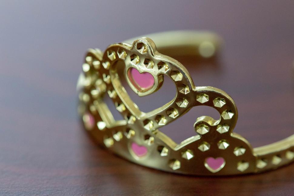 Free Image of A gold crown with pink hearts on it 