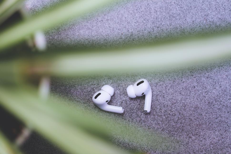 Free Image of A pair of white earbuds on a carpet 