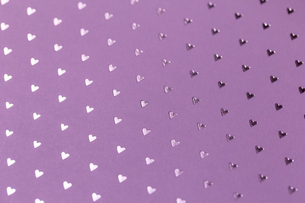 Free Image of A purple background with small silver hearts 