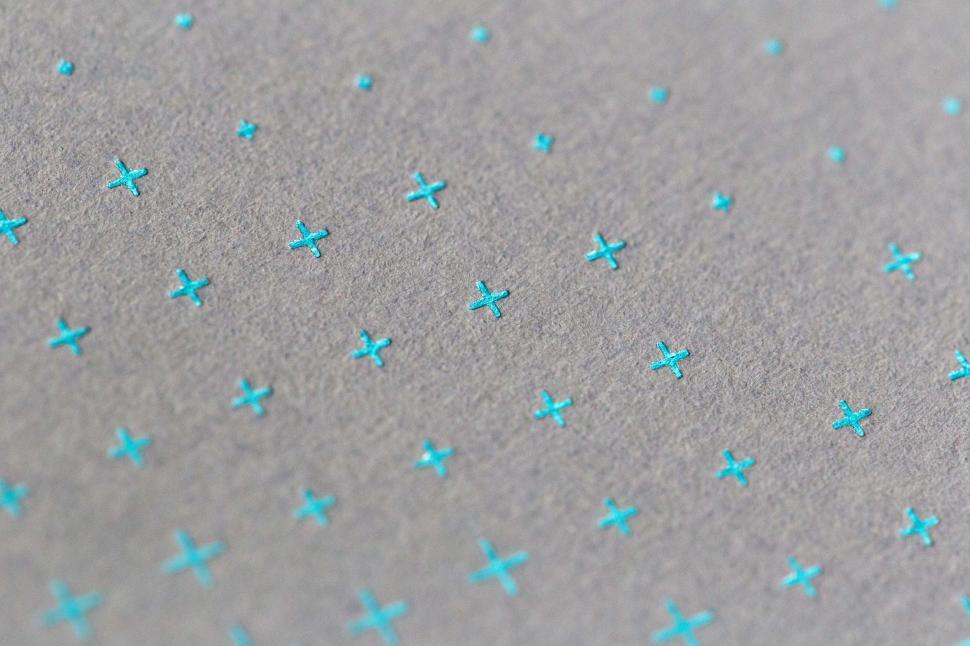 Free Image of A group of blue crosses on a grey surface 