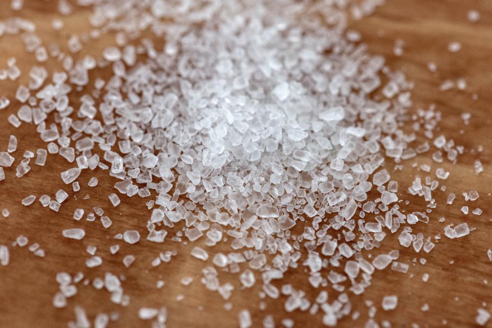 Free Image of A pile of white crystals on a wooden surface 