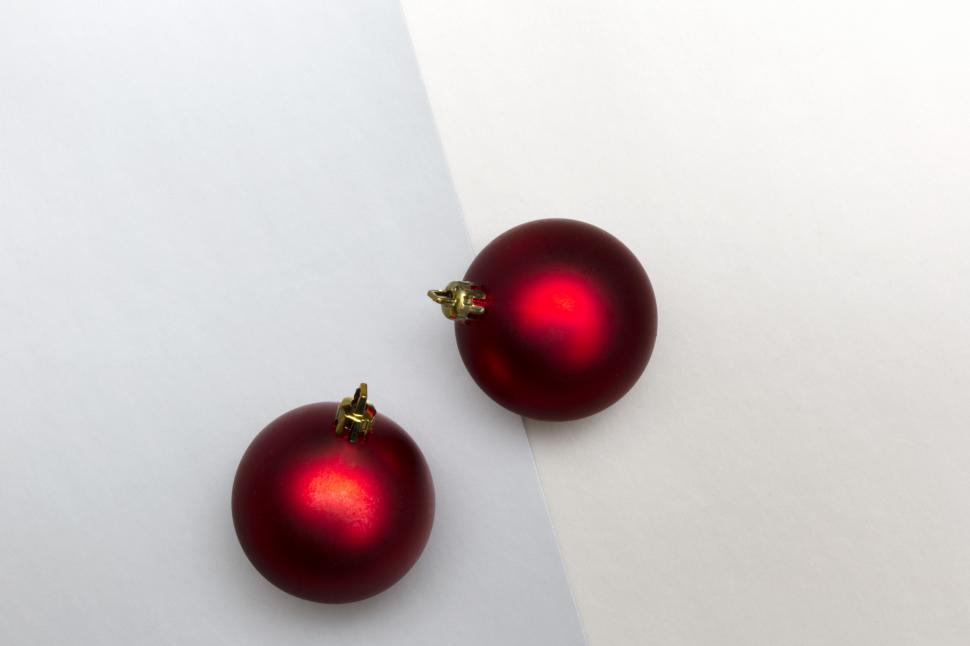 Free Image of Two red ornaments on a white and gray surface 