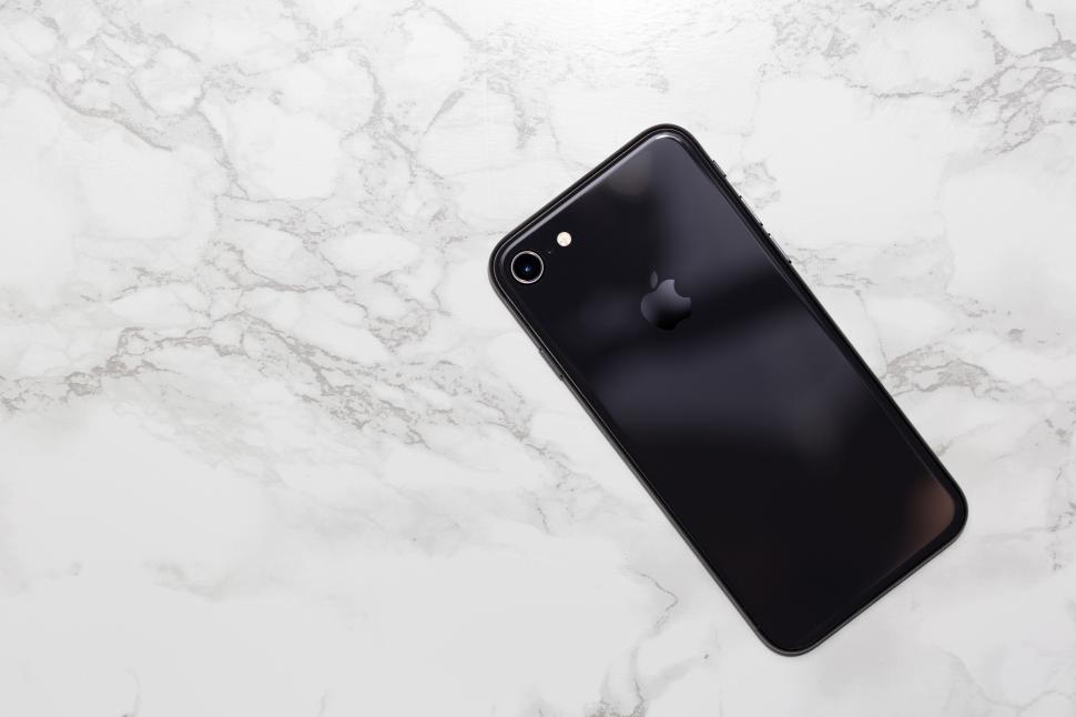 Free Image of A black cell phone on a marble surface 