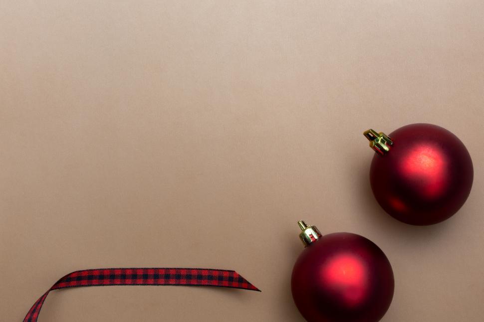 Free Image of Two red ornaments next to a ribbon 