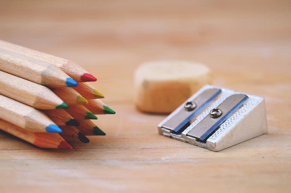 Free Image of A group of colored pencils next to a sharpener 