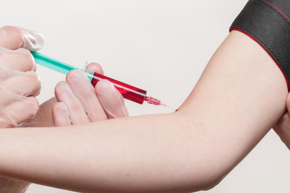 Free Image of A person injecting a red liquid into a person s arm 