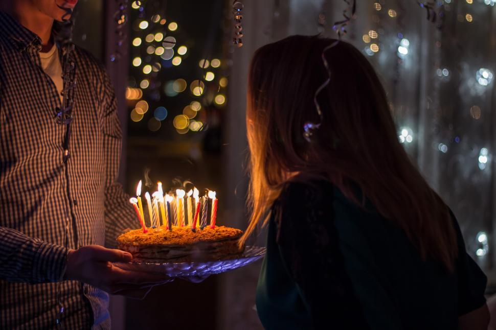 Free Image of A woman holding a cake with lit candles 