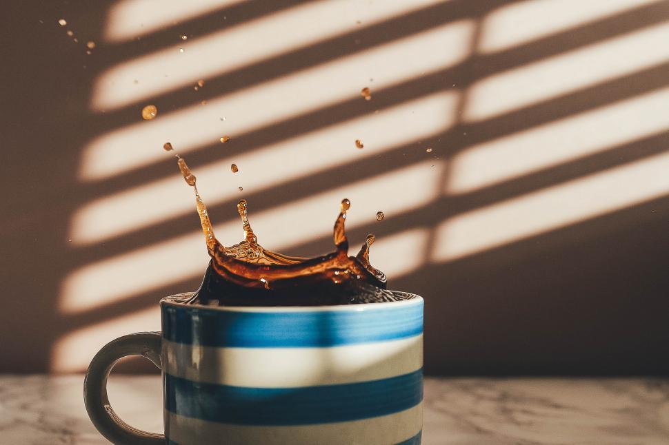 Free Image of A coffee splashing into a cup 