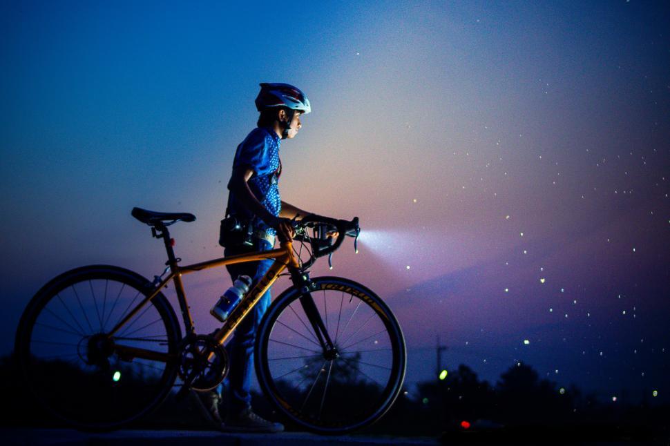 Free Image of A person with a bicycle and a flashlight 
