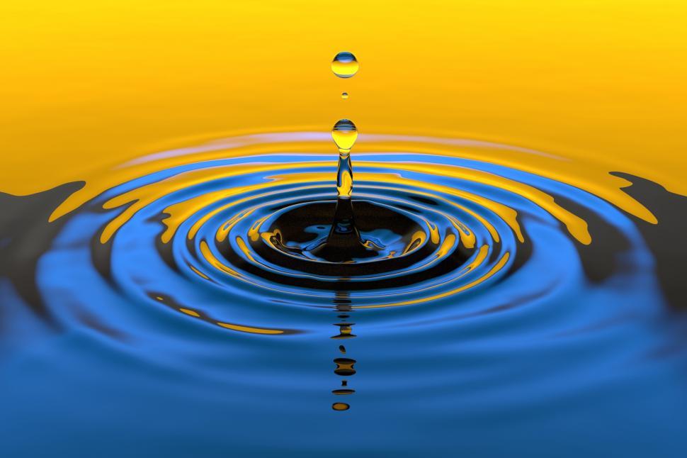 Free Image of A water droplet falling into a blue and yellow surface 