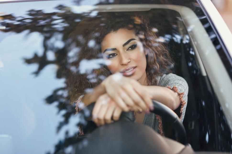 Free Image of Young arabic woman inside a white car looking through the window 