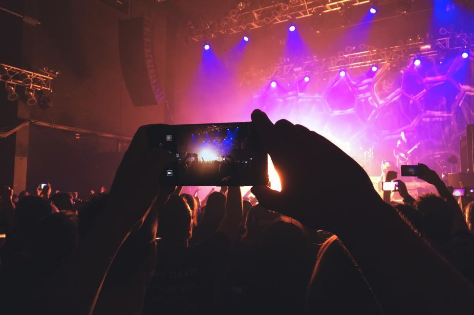 Free Image of A person holding a cell phone in front of a stage 