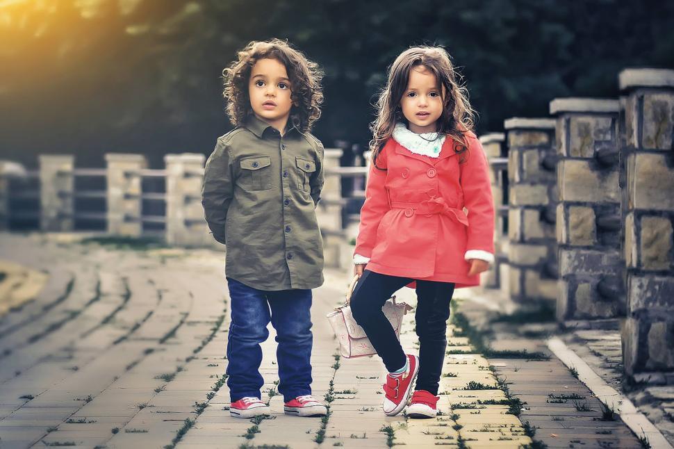 Free Image of Two children standing on a brick path 