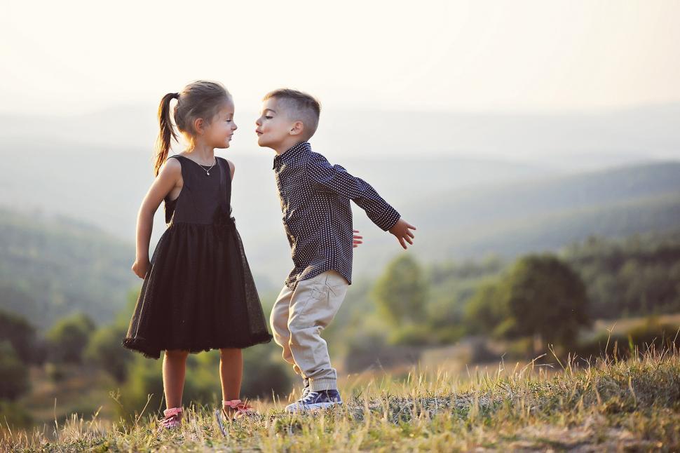 Free Image of A boy and girl standing in a grassy area 