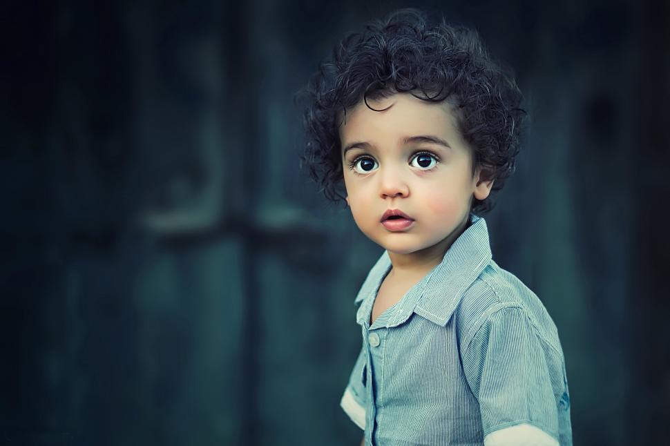 Free Image of A child with curly hair looking at the camera 