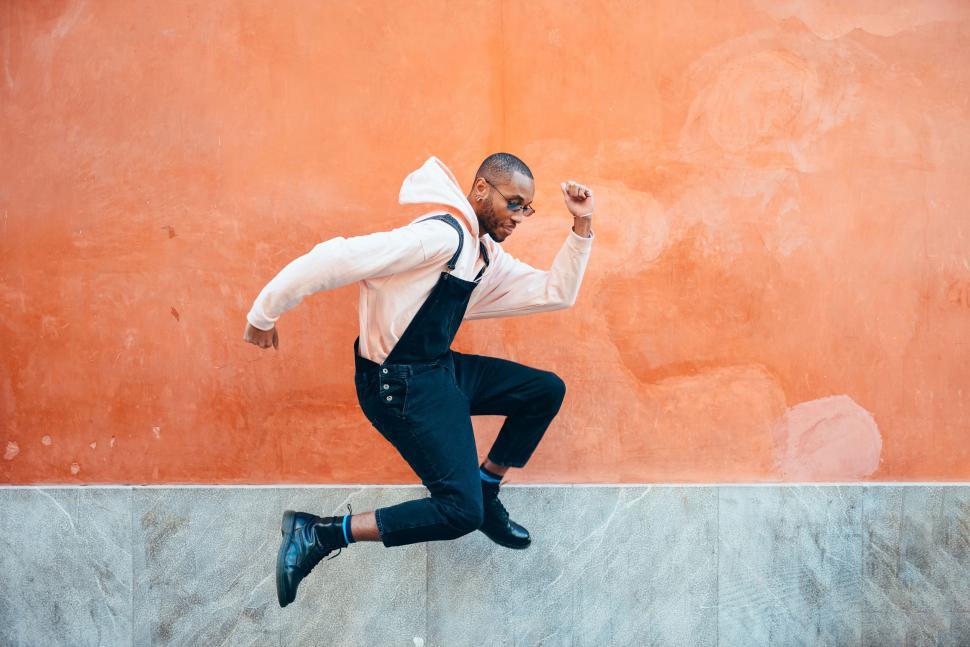 Free Image of Young black man wearing casual clothes jumping outdoors 