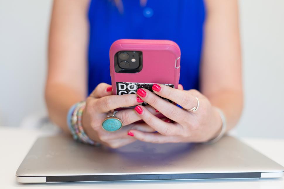 Free Image of A woman holding a pink phone 