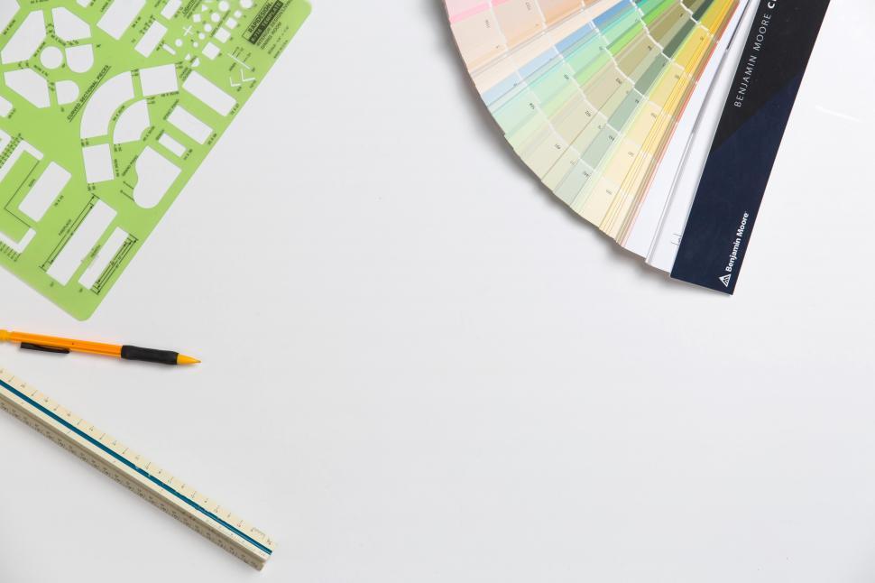 Free Image of A table with a fan of color swatches and a ruler 