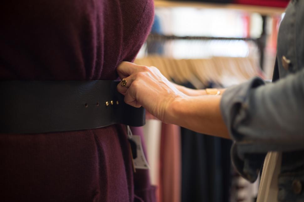 Free Image of A person adjusting a belt on a dress 