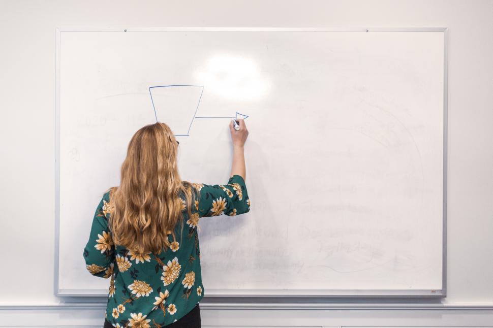 Free Image of A woman writing on a whiteboard 